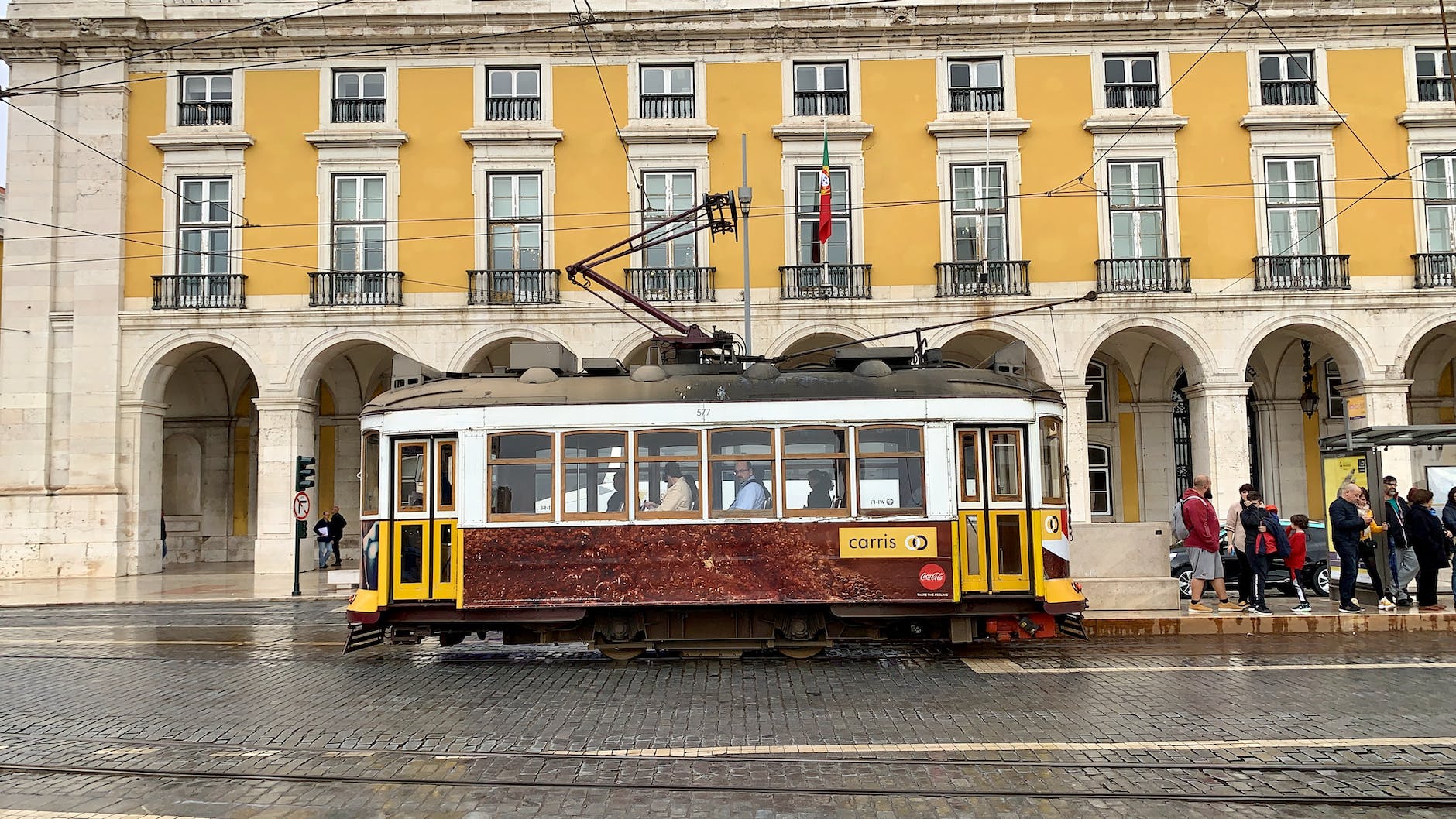 yellow and red tram near white concrete building